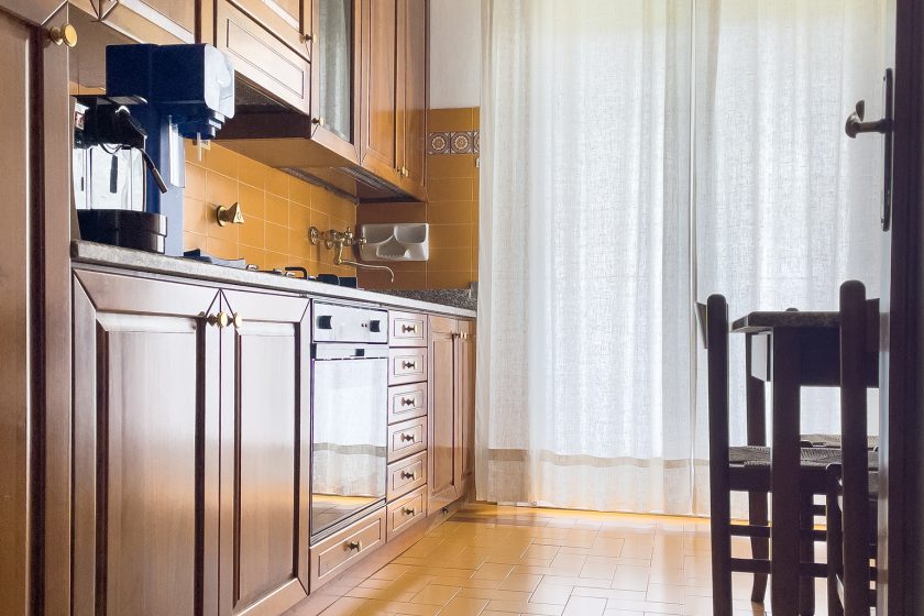 Cucina abitabile in stile classico con un tavolo a 4 posti ed elettrodomestici